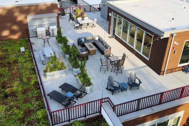 Rooftop terrace with lounge seating, grilling area, and outdoor dining at Admiral Station Apartments.