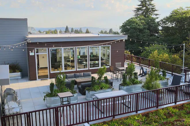 Outdoor rooftop lounge with fire pit seating and gathering spaces at Admiral Station Apartments.