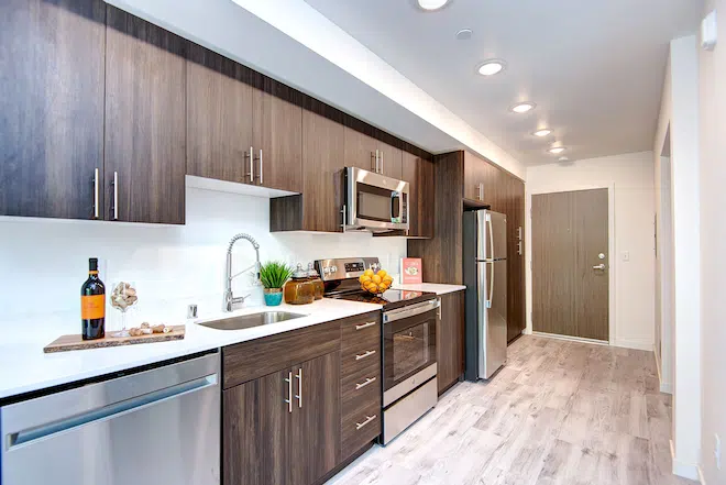 Modern apartment kitchen with quartz countertops, stainless steel appliances, and contemporary cabinetry.