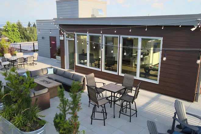 Aerial view of the rooftop lounge with outdoor seating and gathering spaces at Admiral Station Apartments.
