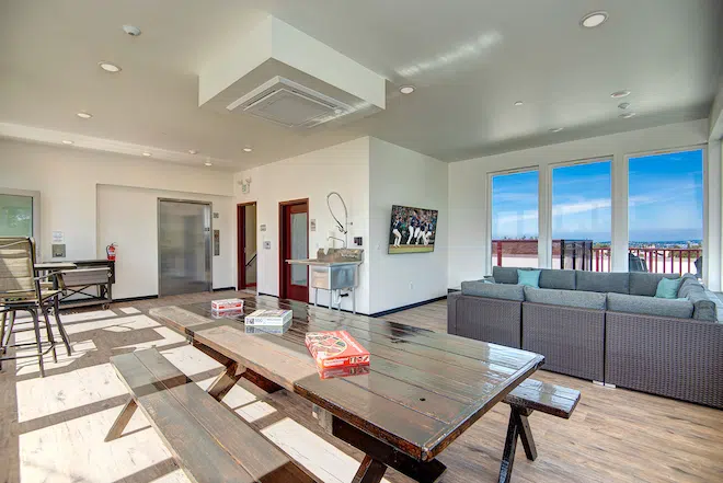Rooftop clubhouse with lounge seating, games, and panoramic city views.